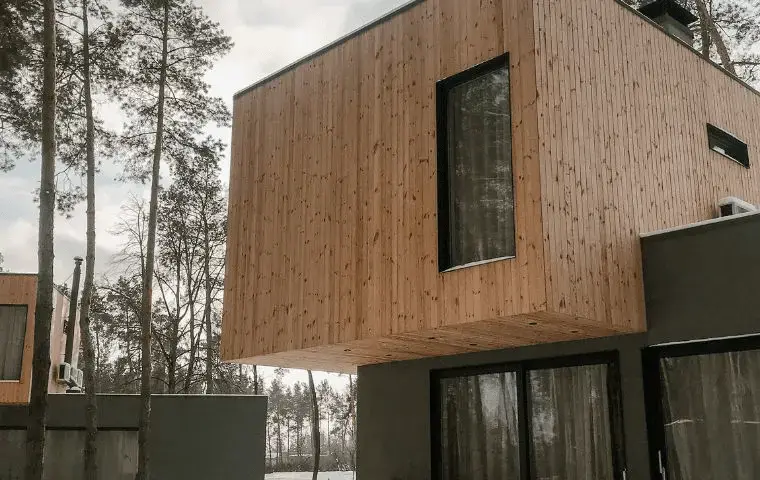 casa de madera moderna de dos plantas con grandes ventanales