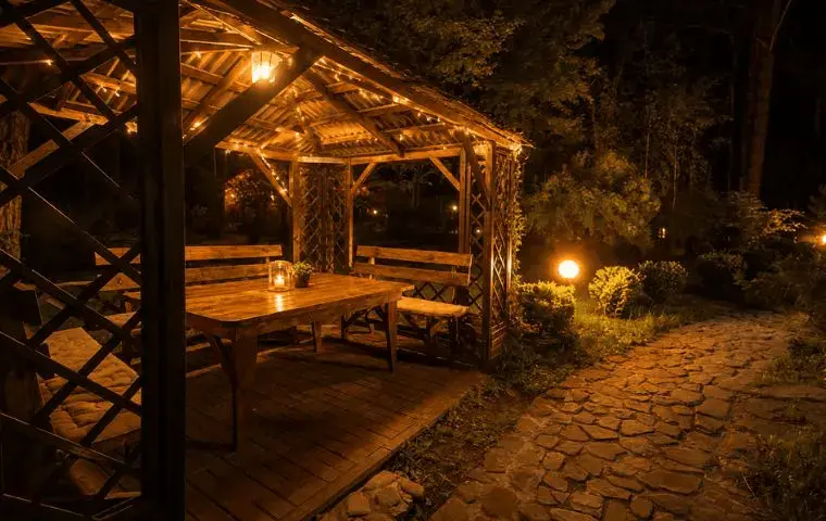 cenador de madera iluminado con mesa y bancos